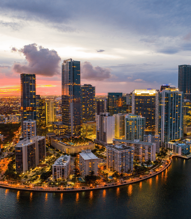 Aerial view of Brooklyn skyline at sunset, showcasing modern skyscrapers and waterfront, emphasizing real estate opportunities and local culture.