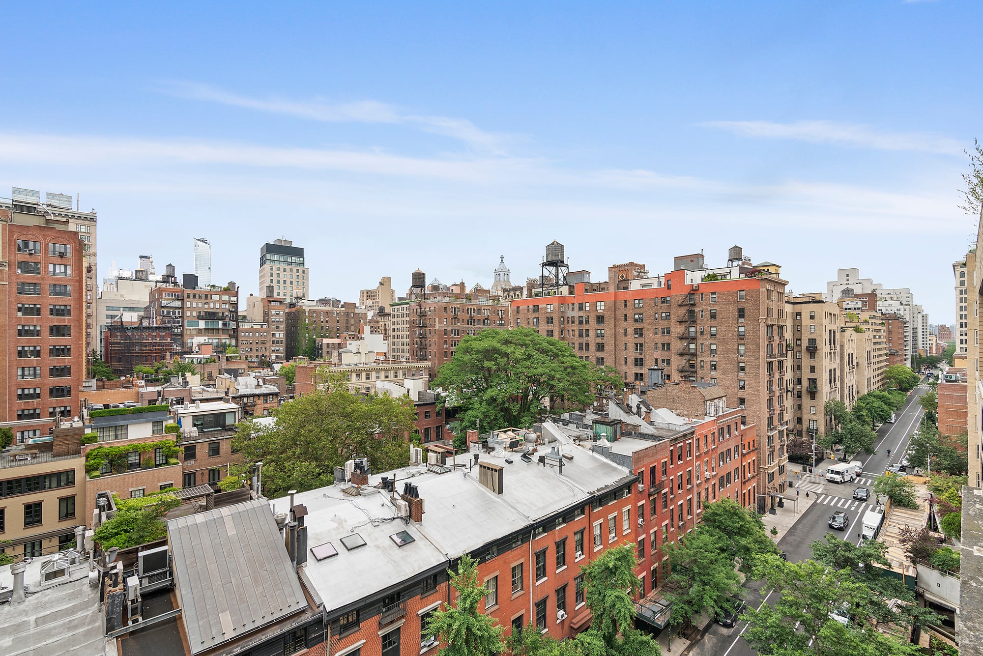 Brooklyn cityscape featuring residential buildings, tree-lined streets, and a clear blue sky, representing the vibrant neighborhoods explored by local real estate expert Maxine McClinton.